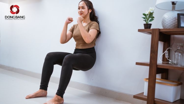 Tập squat với tường, dồn lực vào chân là chủ yếu 